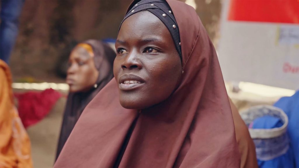 A woman in a headscarf sitting among a group of women.